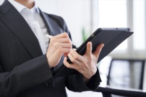 A businessperson holds a tablet and pen.