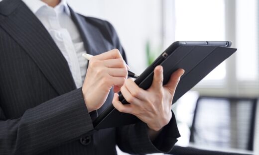 A businessperson holds a tablet and pen.