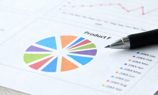 A pen rests on top of a colourful pie chart, perhaps indicating sales growth or a marketing and PR strategy.