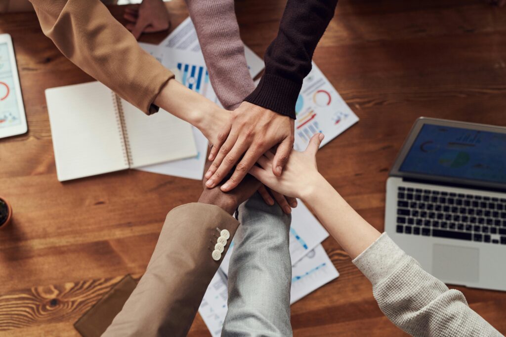 Business people put their hands together in a show of team spirit.