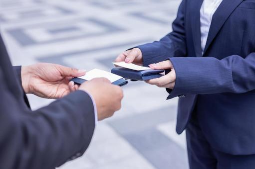 Two business people exchange business cards.
